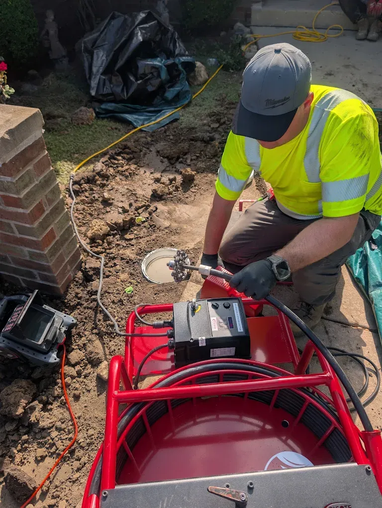 A drain machine cable feeding into a residential cleanout.