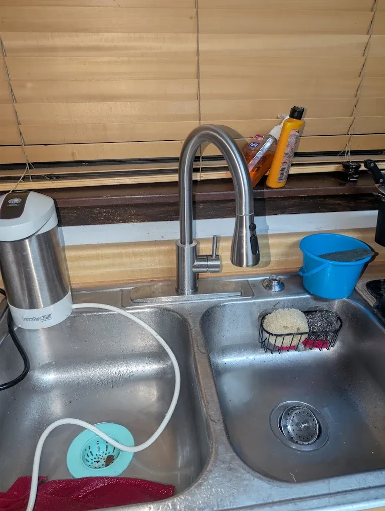 A double-basin kitchen sink with a high-arc faucet.