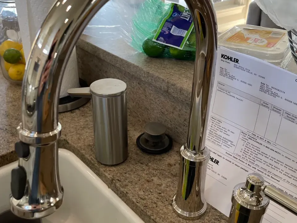 A pull-down kitchen faucet and soap dispenser installed on a granite counter.