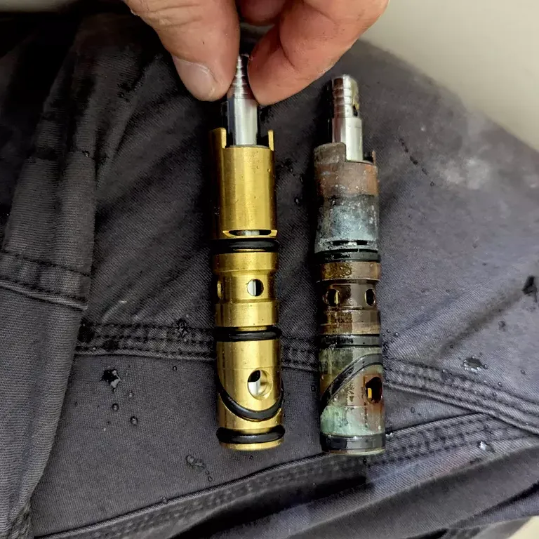 Old and new shower cartridges side by side.