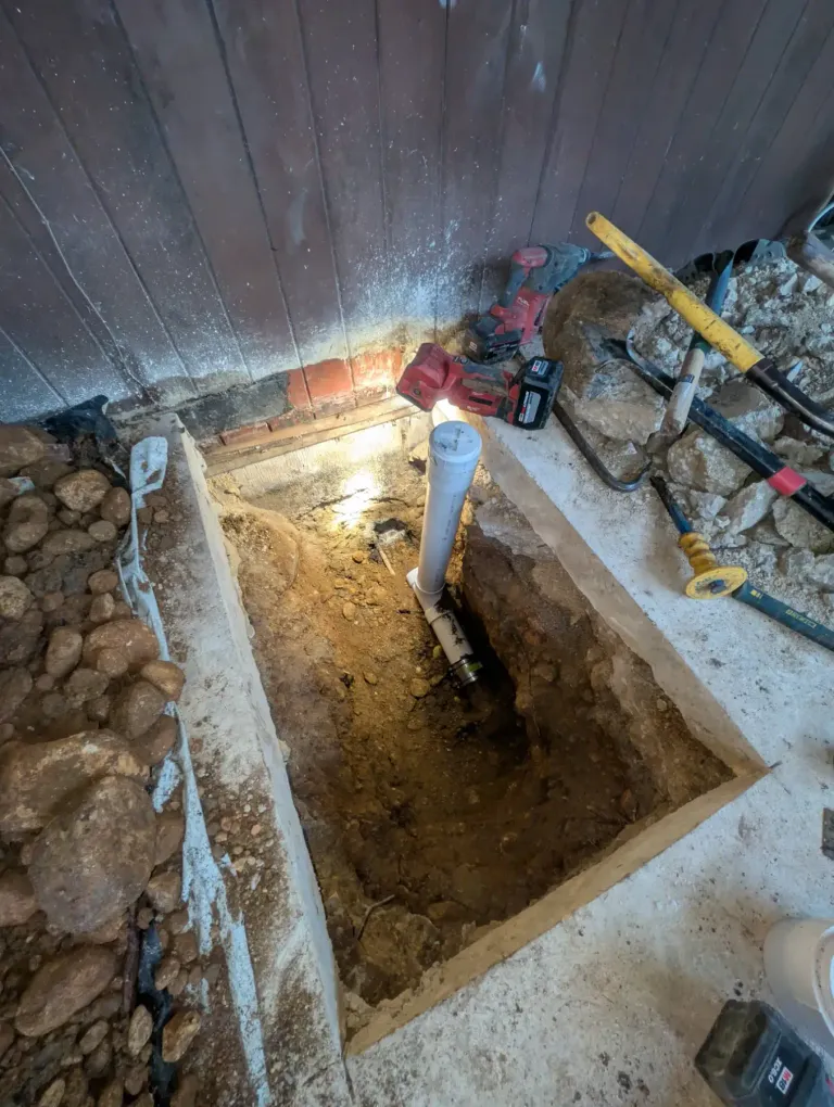PVC pipe coming out of an excavated hole.