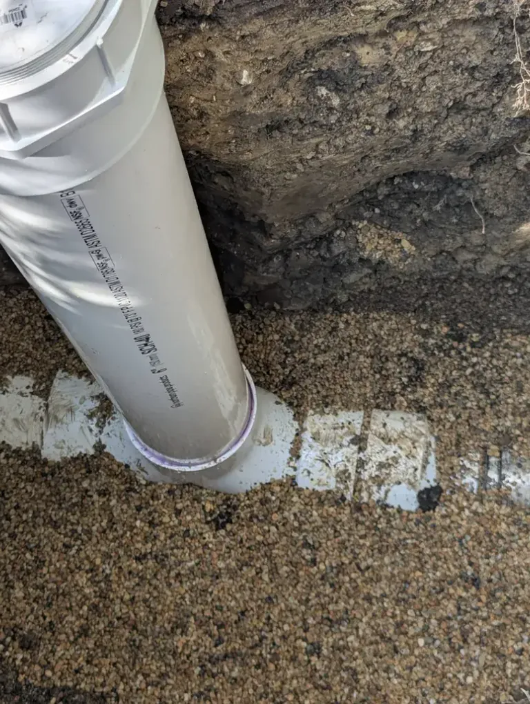 PVC pipe laid in an excavated hole.