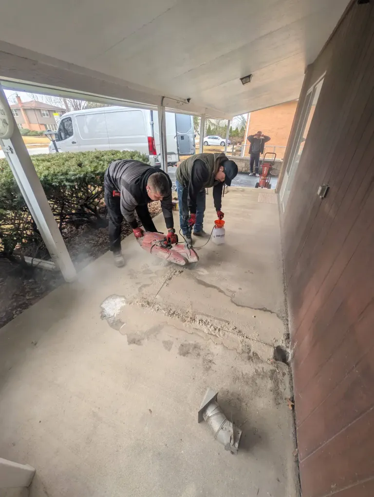 Workers cutting cement to open a repair.