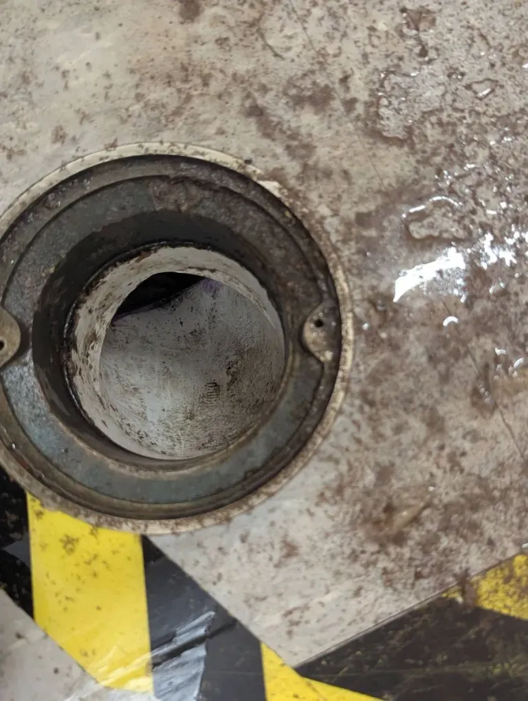 Round cleanout opening in a floor.