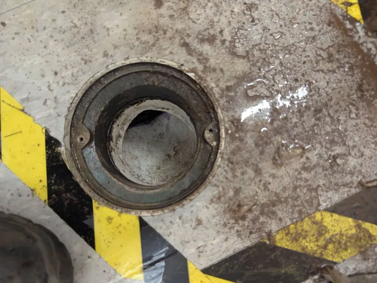 Round cleanout opening in a floor.