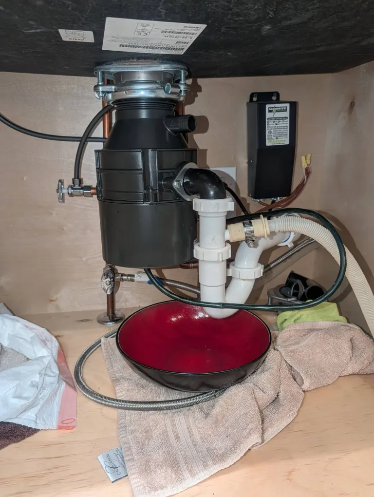 Garbage disposal installed under a sink.