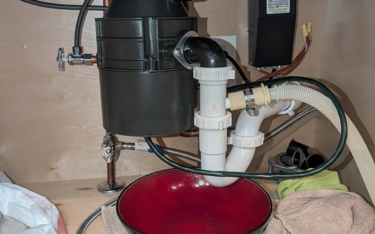 Garbage disposal installed under a sink.