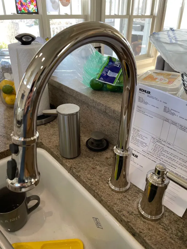 Chrome kitchen faucet with boxed replacement parts.