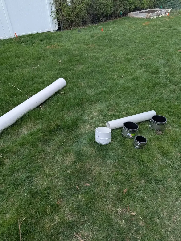 White replacement pipe sections on grass.
