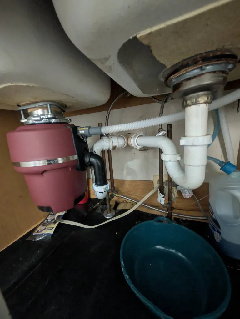 Leaking PVC under a sink next to a garbage disposal.
