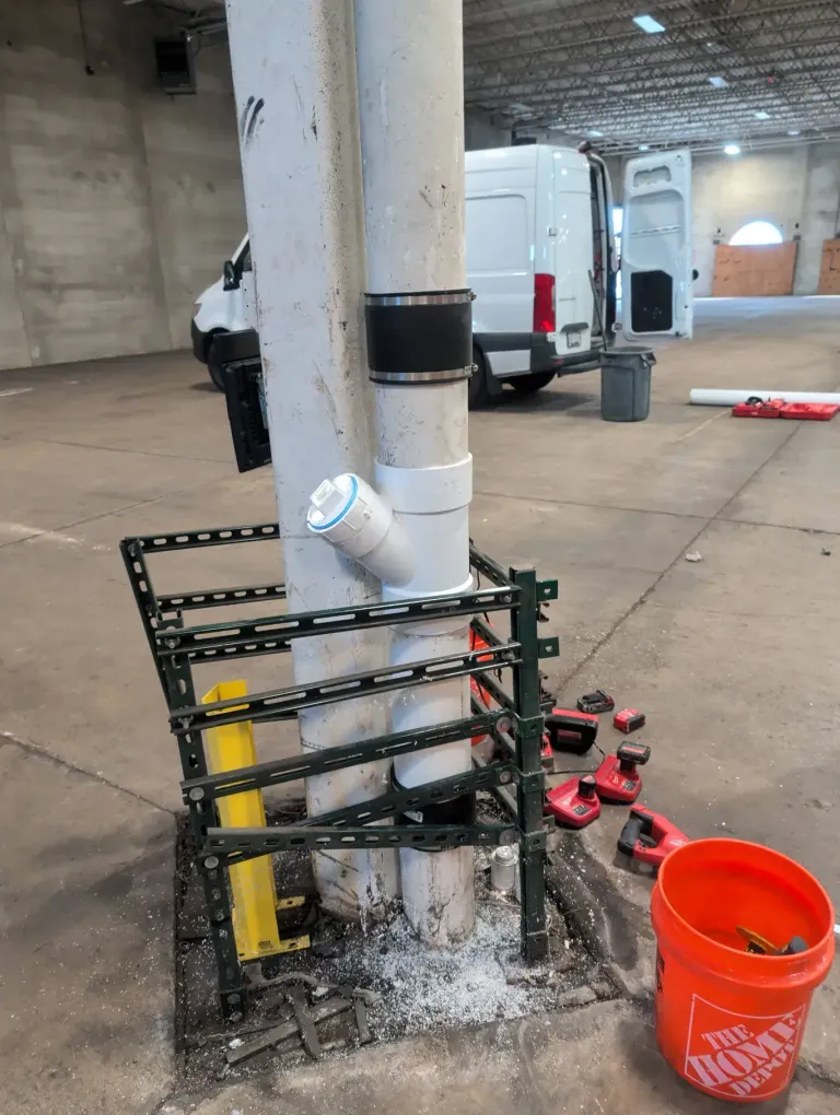 PVC staged on the floor during warehouse ceiling pipe work.